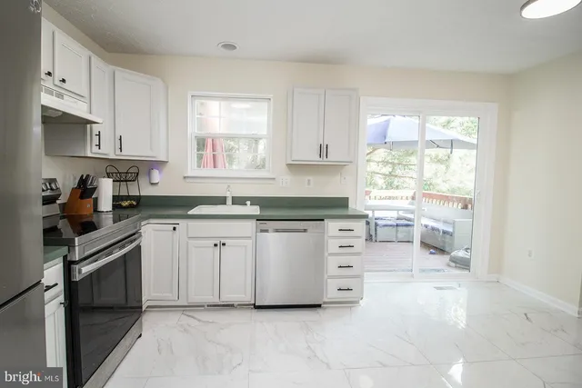 a kitchen with white cabinets and white appliances