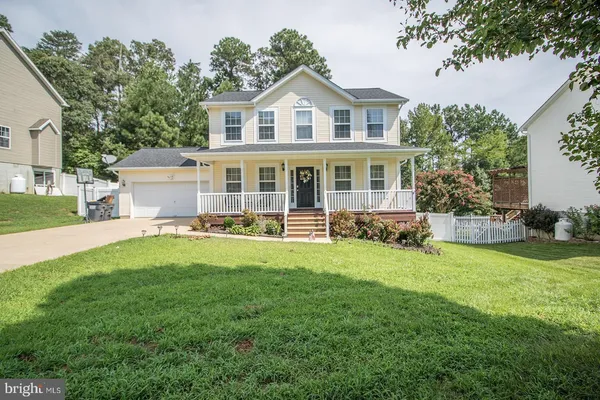 a view of a house with a yard and sitting area