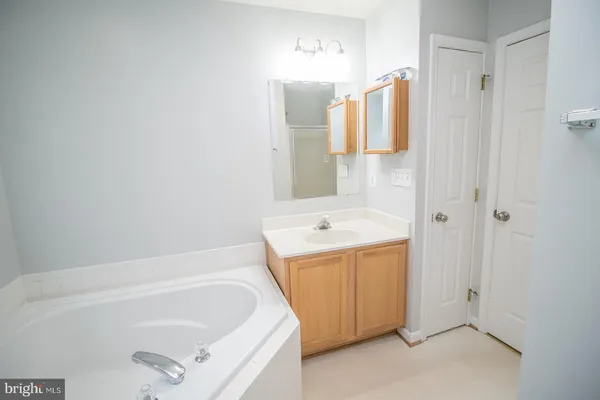 a bathroom with a tub a sink and dryer