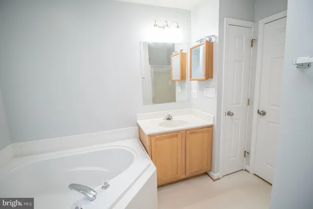 a bathroom with a tub a sink and dryer