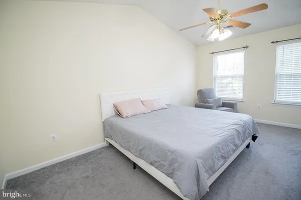 a bedroom with a bed and a chandelier fan