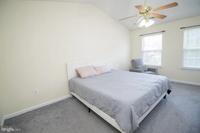 a bedroom with a bed and a chandelier fan