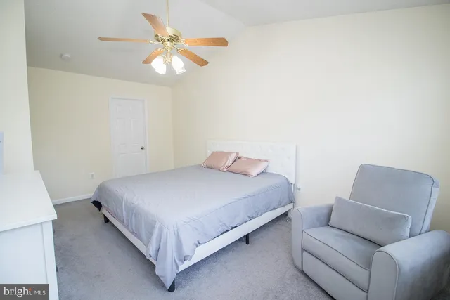 a bedroom with a bed couch and ceiling fan
