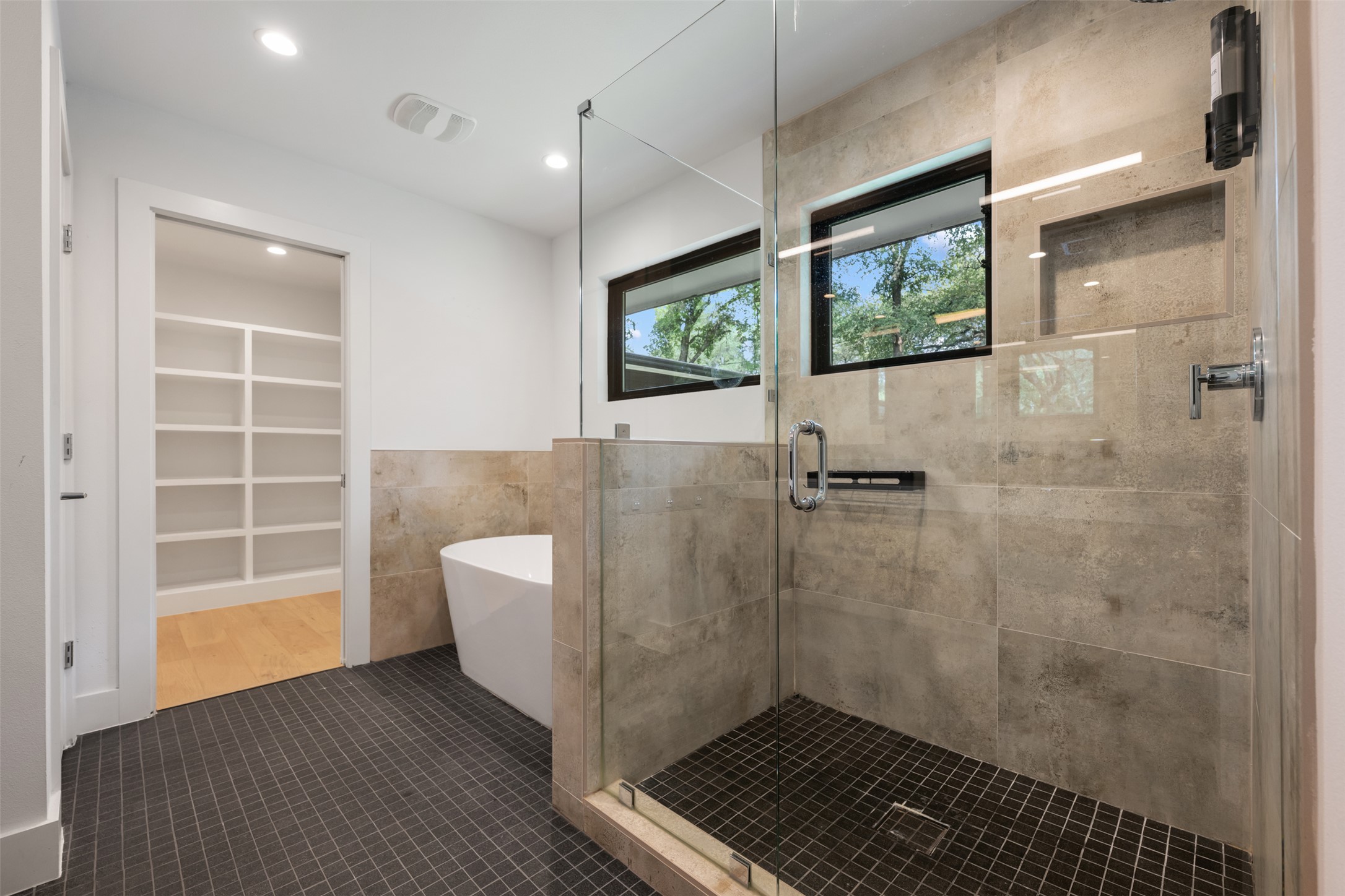 8900 Point W Drive Austin, TX 78759 - Photo 26 of 40 A well-lit primary bathroom features a spacious glass-enclosed shower, deep soaking tub, and ample storage.