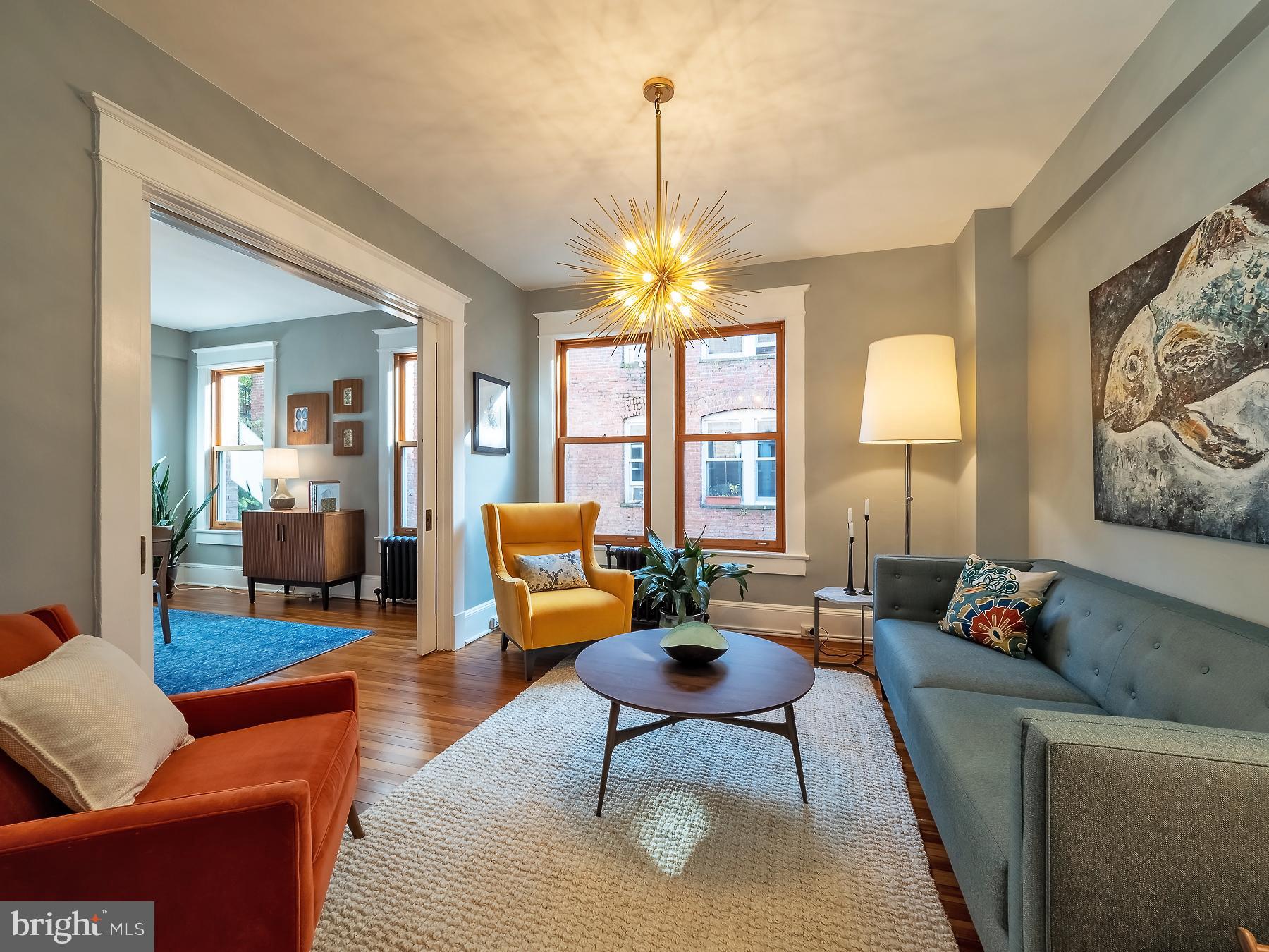 a living room with furniture a chandelier and a window