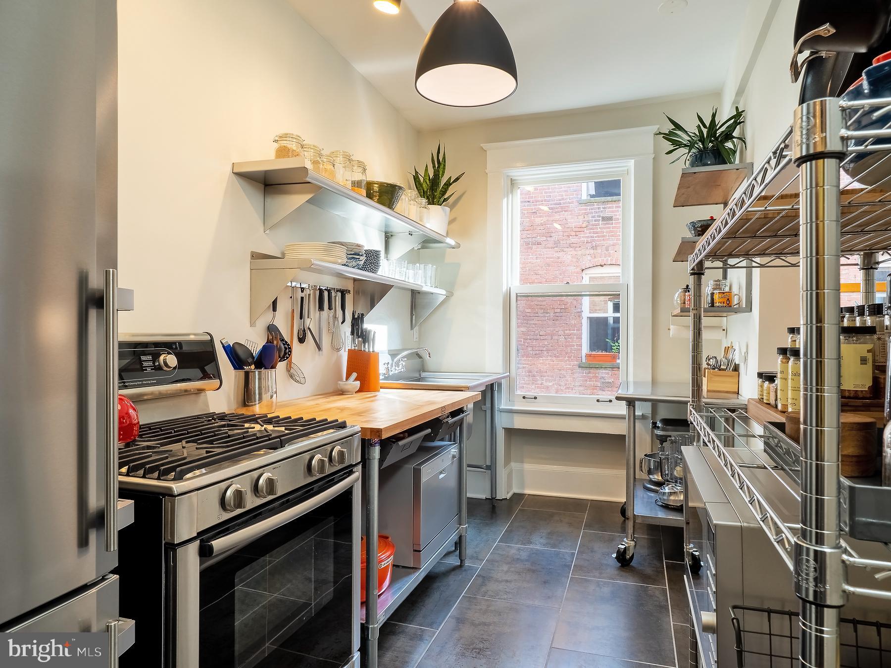1736 Columbia Road Northwest, Unit 309 Washington, DC 20009 - Photo 15 of 38 a kitchen that has a stove and a table in it