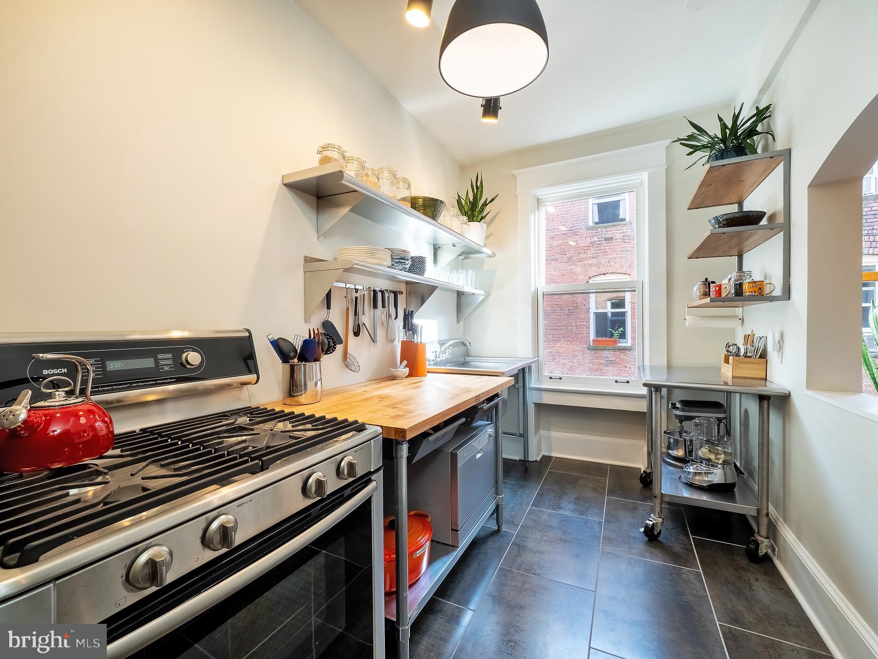 1736 Columbia Road Northwest, Unit 309 Washington, DC 20009 - Photo 16 of 38 a kitchen with a stove and cabinets