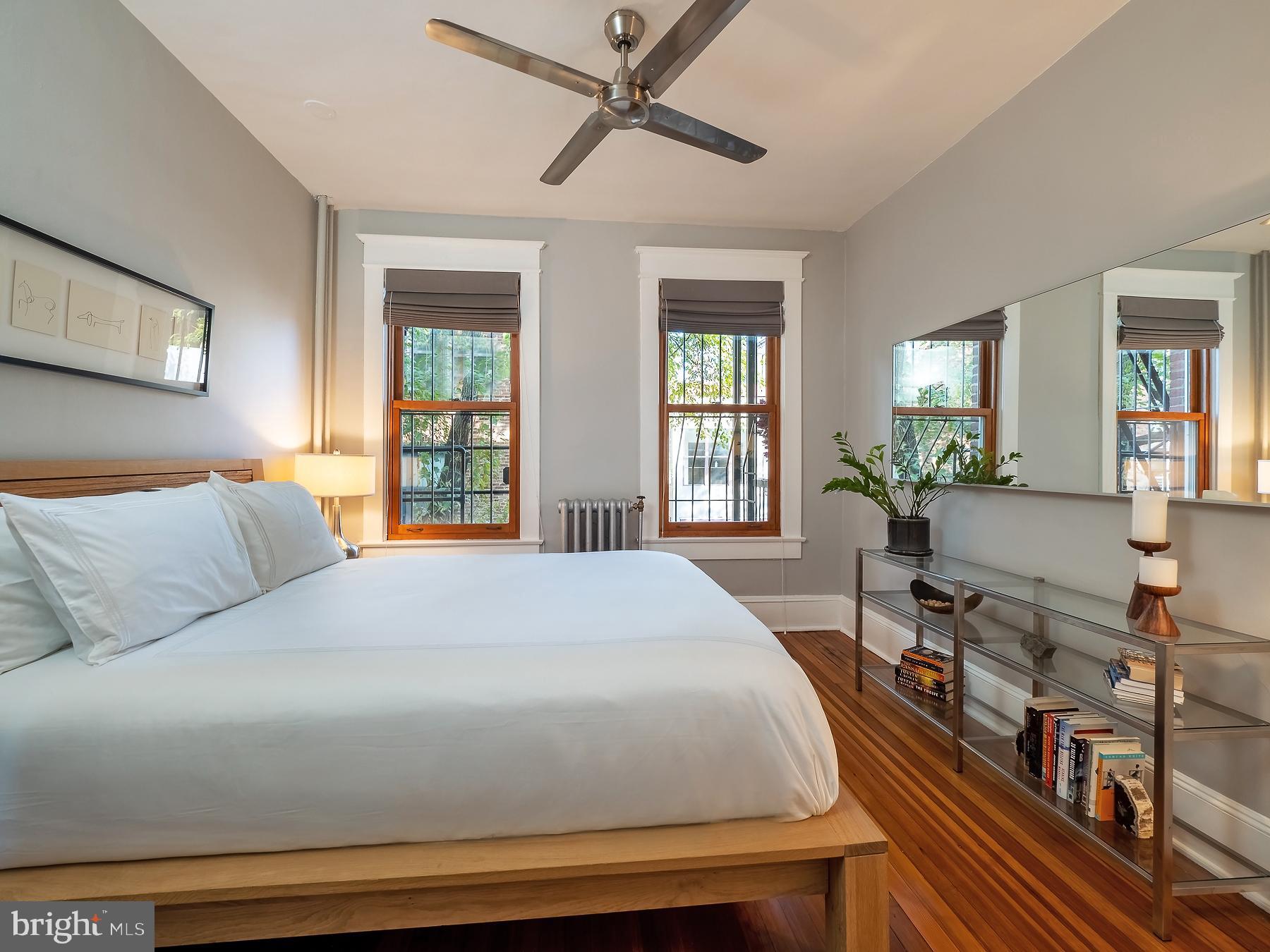 1736 Columbia Road Northwest, Unit 309 Washington, DC 20009 - Photo 19 of 38 a bedroom with a large bed a chandelier and windows
