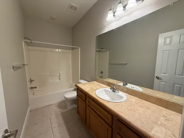 a bathroom with a granite countertop sink a toilet and shower