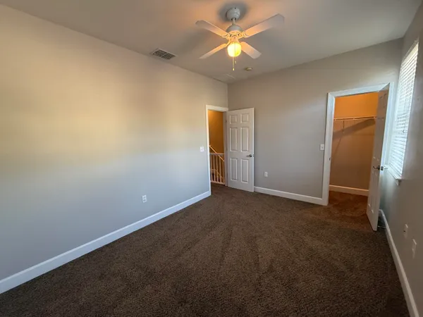 an empty room with a ceiling fan and a window