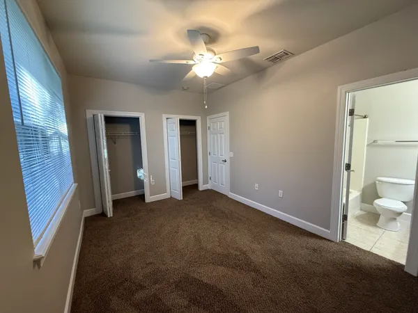 a view of a room with a ceiling fan and bathroom space