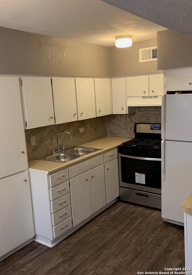 615 Vance Jackson Road, Unit 210 San Antonio, TX 78201 - Photo 3 of 10 a kitchen with granite countertop white cabinets and white appliances