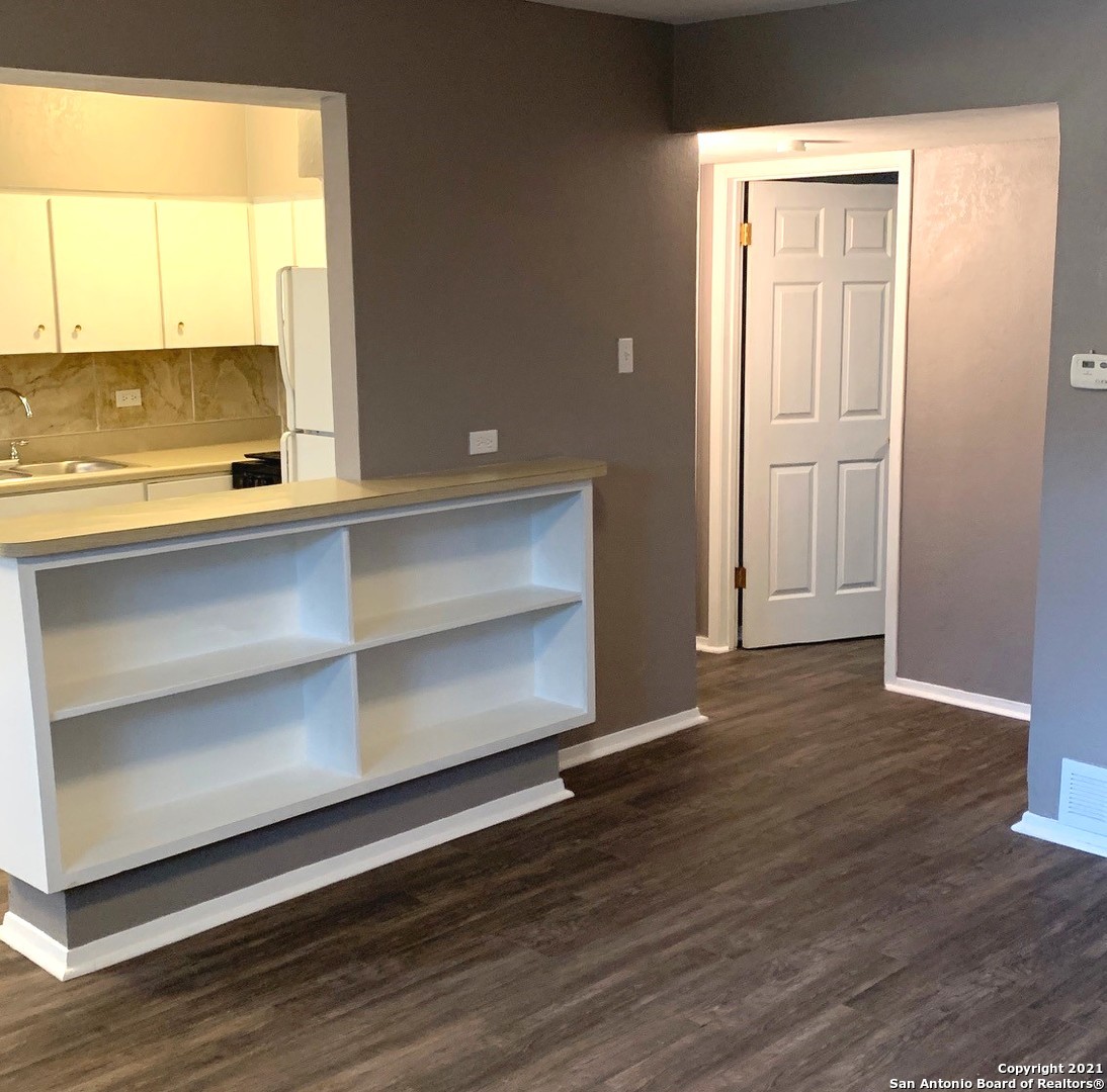 615 Vance Jackson Road, Unit 210 San Antonio, TX 78201 - Photo 5 of 10 a view of an empty room with wooden floor and a window