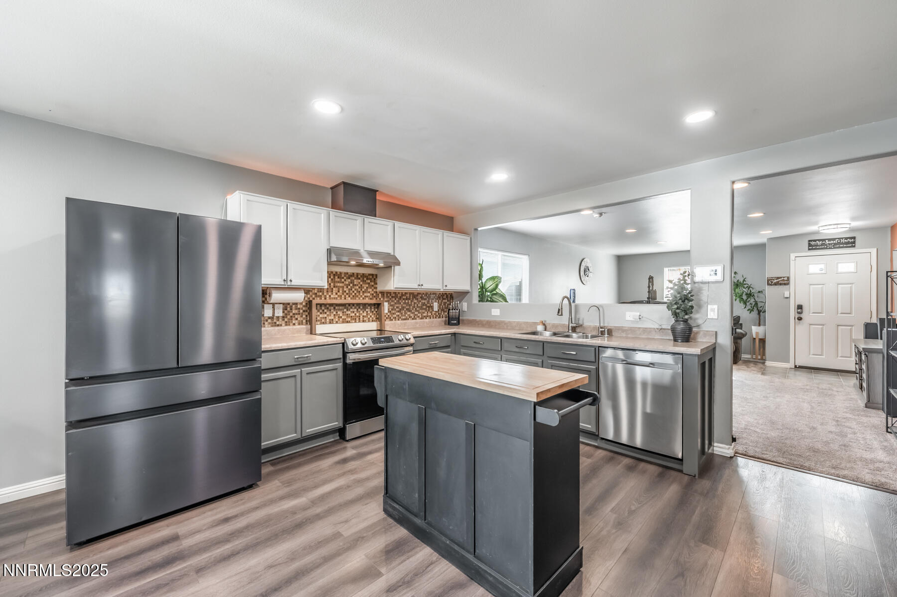 7447 Findhorn Drive Reno, NV 89506 - Photo 9 of 27 a kitchen with stainless steel appliances granite countertop a refrigerator a stove a sink dishwasher a refrigerator and white cabinets with wooden floor