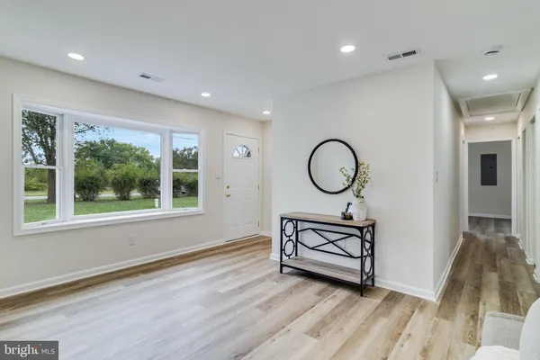 a view of a room with wooden floor wooden cabinet and windows
