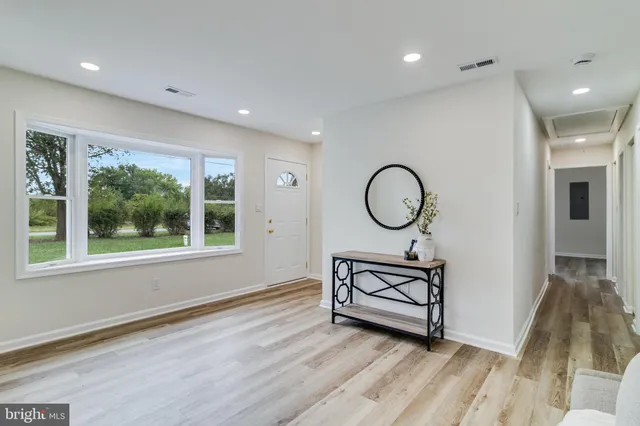 a view of a room with wooden floor wooden cabinet and windows