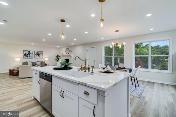 a kitchen with kitchen island granite countertop a stove a sink a center island and windows