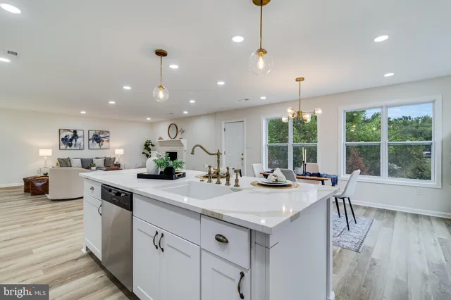 a kitchen with kitchen island granite countertop a stove a sink a center island and windows