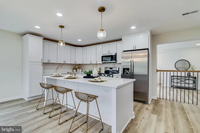 a kitchen with kitchen island a refrigerator a stove a center island a dining table and chairs