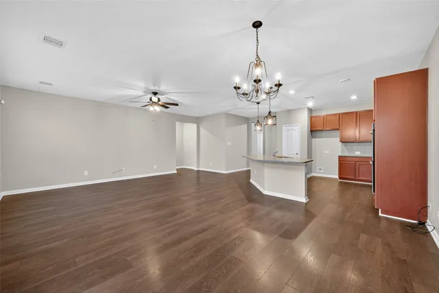 a view of a big room with wooden floor and windows