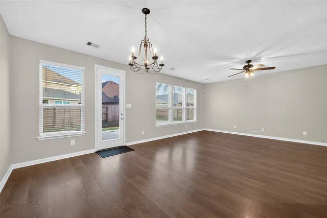 a view of a hallway with wooden floor and a white door