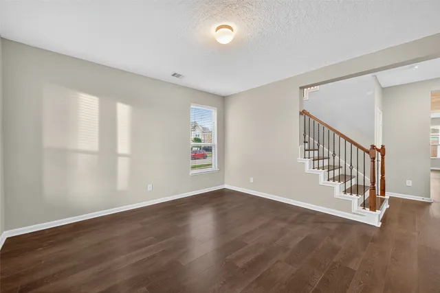 a view of an empty room with wooden floor