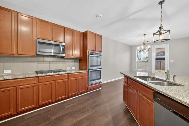 a kitchen with stainless steel appliances granite countertop a sink stove and refrigerator