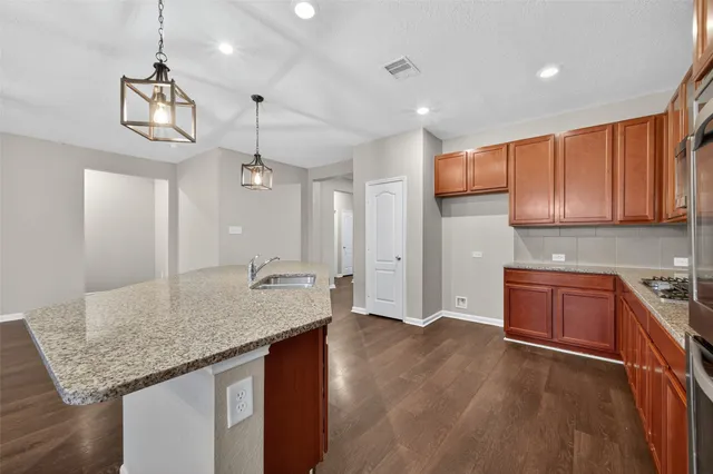 a kitchen with kitchen island granite countertop wooden cabinets and a granite counter tops