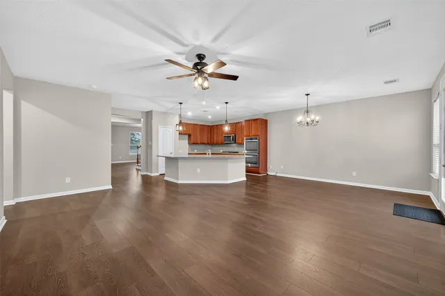 a view of a kitchen with a ceiling fan wooden floor and a ceiling fan