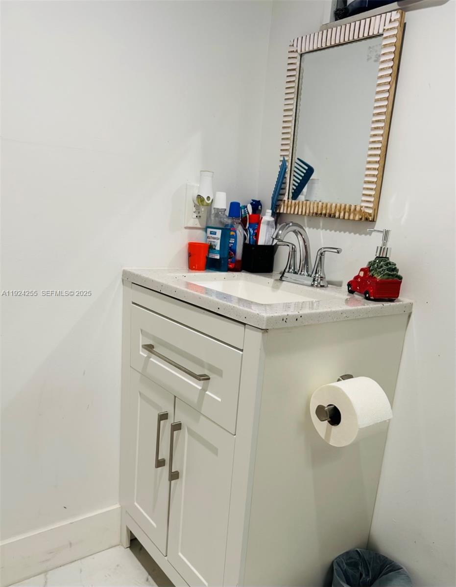 6831 Southwest 2nd Street, Unit FRONT Miami, FL 33144 - Photo 7 of 8 a bathroom with a sink and a mirror