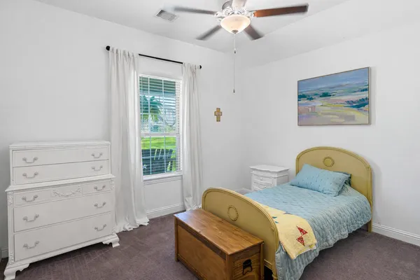 a bedroom with a bed a couch and a large window