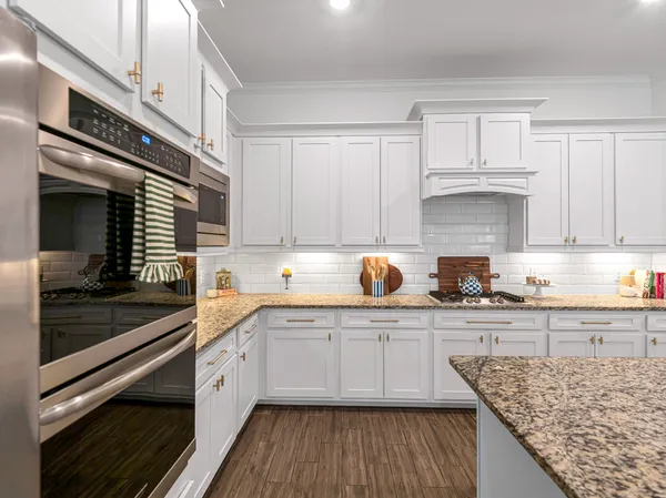 a bathroom with a granite countertop tub a sink and a large mirror
