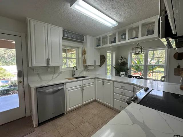 a kitchen with cabinets appliances and a window