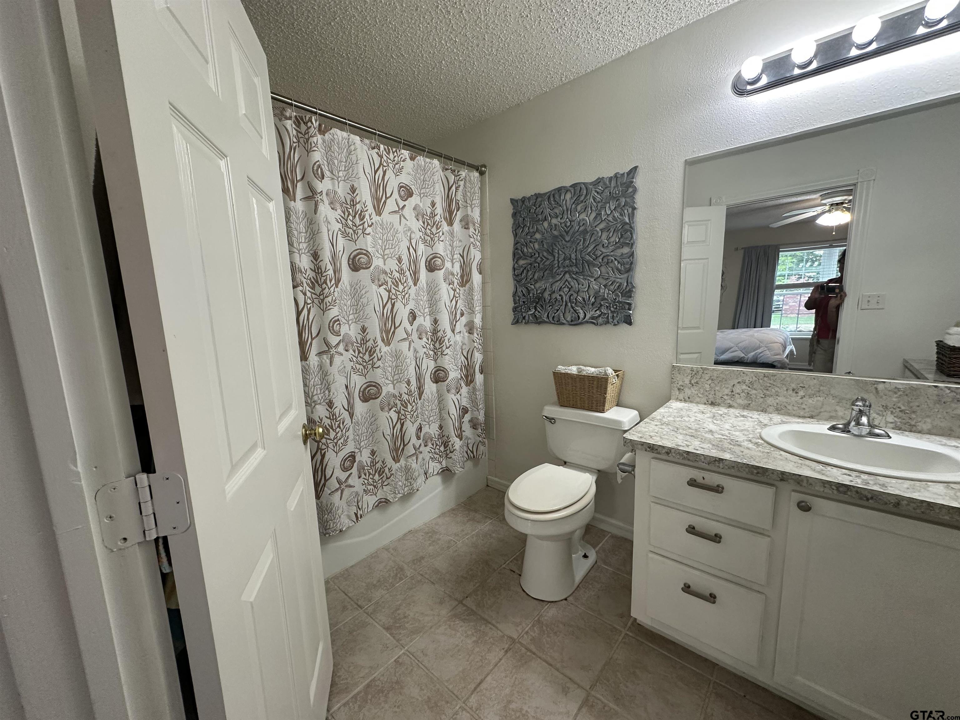 2281 Fm 241s Rusk, TX 75785 - Photo 10 of 31 a bathroom with a granite countertop toilet a sink a mirror a shower curtain