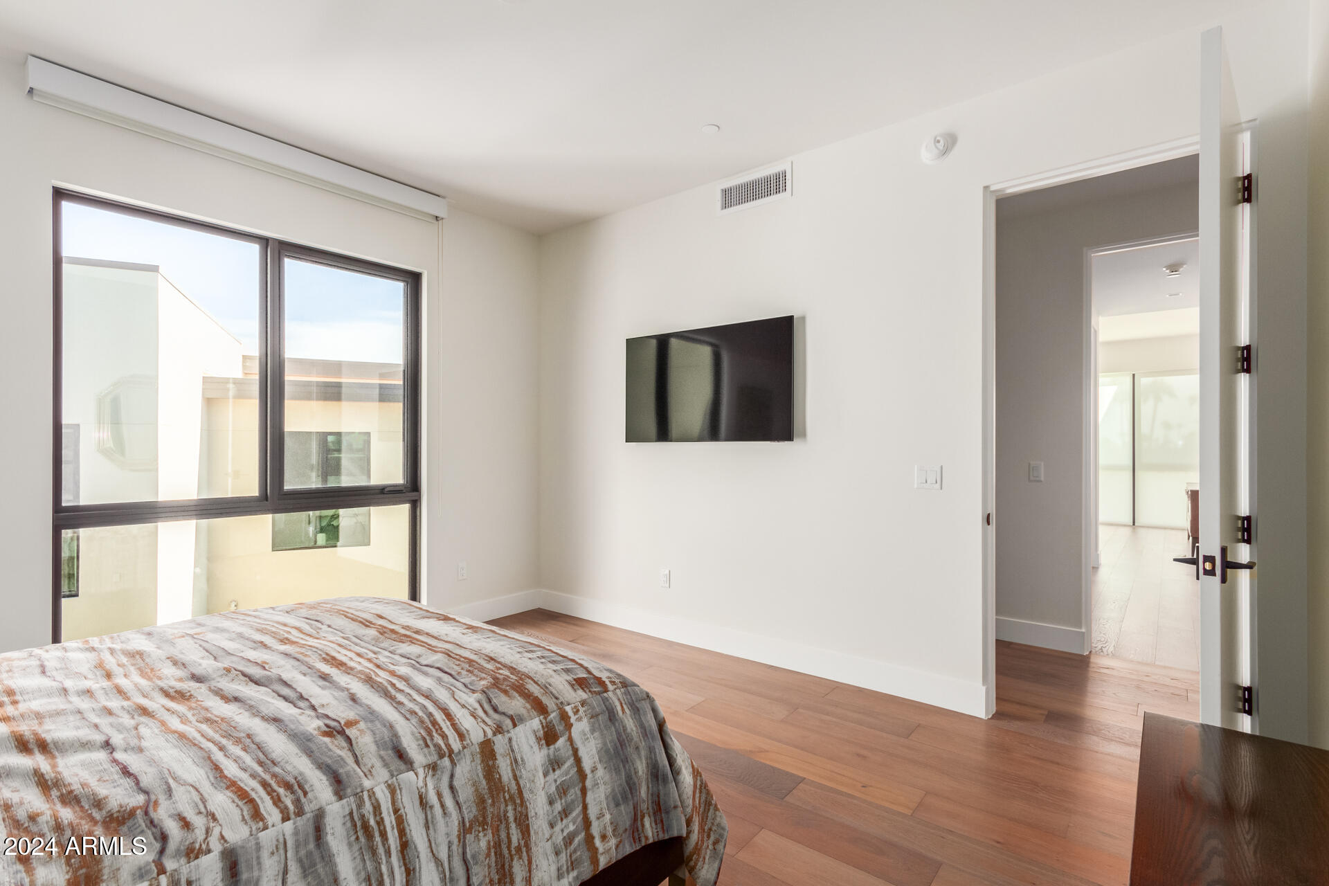 6311 East Phoenician Boulevard, Unit 18 Scottsdale, AZ 85251 - Photo 31 of 45 a bedroom with a bed and a flat tv screen on the dresser