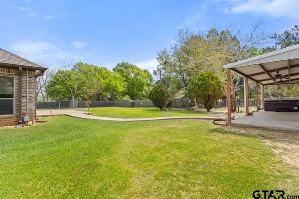 a view of a patio with table and chairs and couches with wooden fence