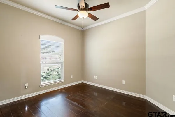 a view of an empty room with a window and wooden floor