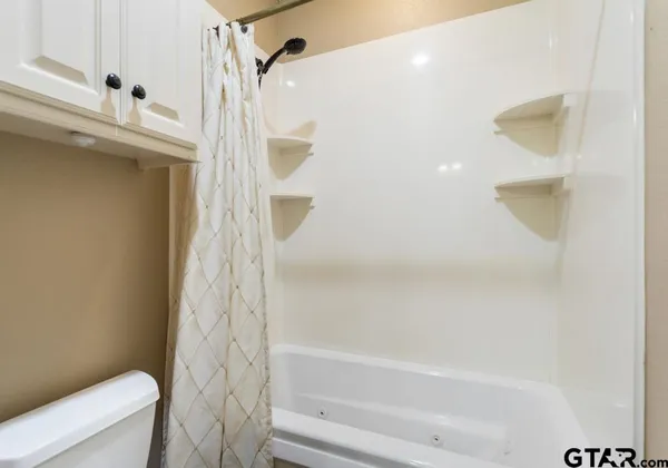 a bathroom with a granite countertop sink a mirror and shower