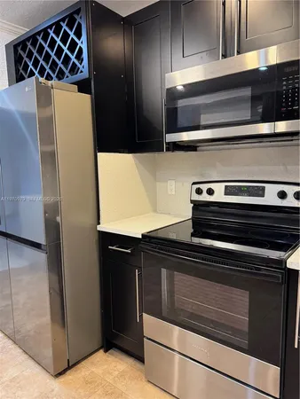 a large kitchen with stainless steel appliances a large counter top