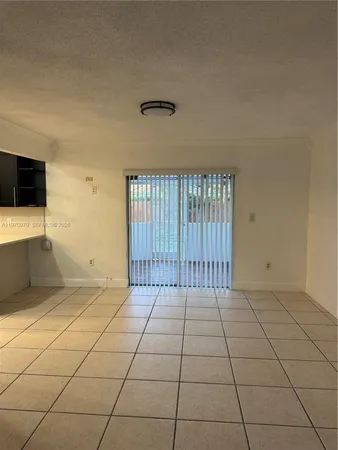 a view of a patio with a table and chairs under an umbrella