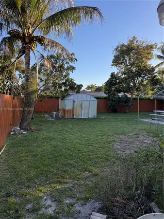 a view of a house with a wooden bench in a patio