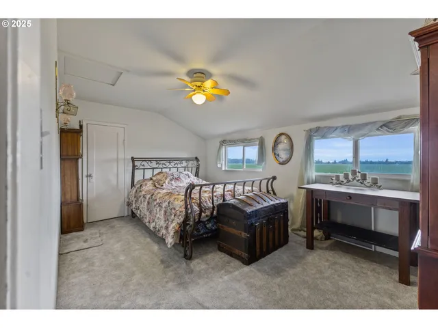 a bed room with a bed and a two large window