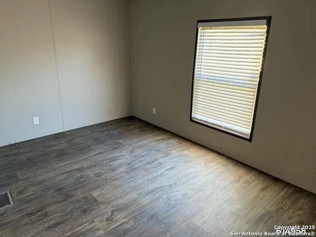 an empty room with wooden floor and a window
