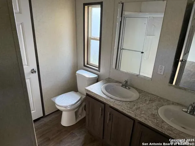 a bathroom with a granite countertop sink toilet and mirror