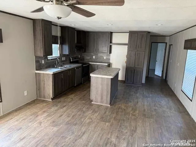 a kitchen with a sink cabinets and wooden floor