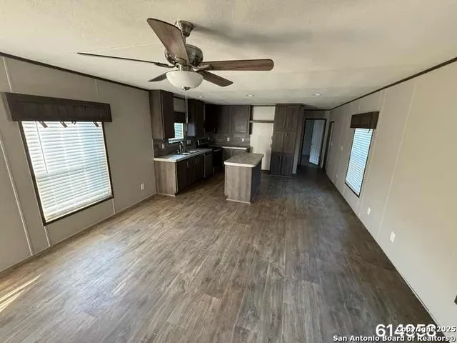 a large kitchen with a wooden floor and stainless steel appliances