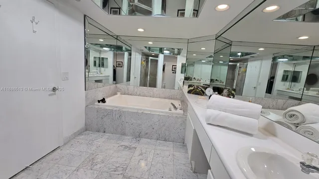 a bathroom with a tub a mirror and shower