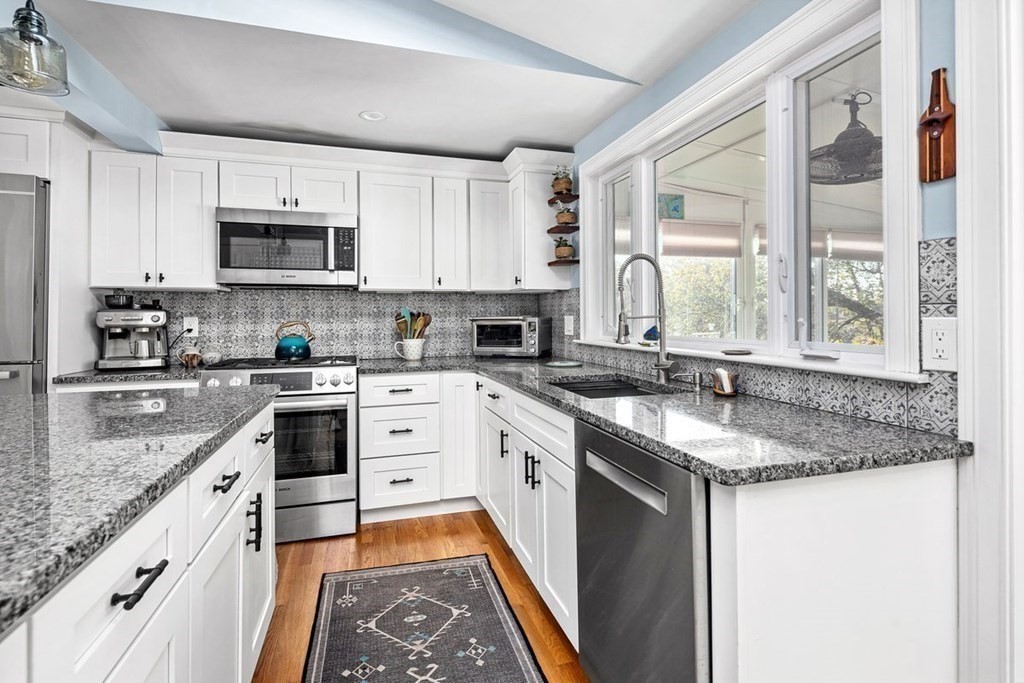 103 Newport Road Hull, MA 02045 - Photo 13 of 40 a kitchen with stainless steel appliances granite countertop a stove a sink and a microwave