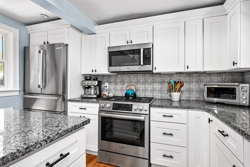 103 Newport Road Hull, MA 02045 - Photo 14 of 40 a kitchen with granite countertop white cabinets stainless steel appliances and a counter space