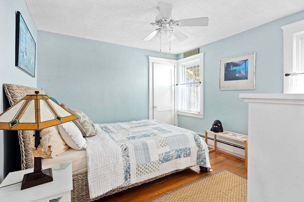103 Newport Road Hull, MA 02045 - Photo 20 of 40 a bedroom with a bed and a chandelier